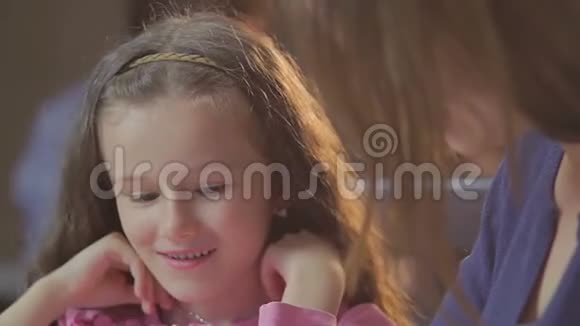 微笑小女孩女儿讲女人妈妈令人兴奋的故事视频的预览图