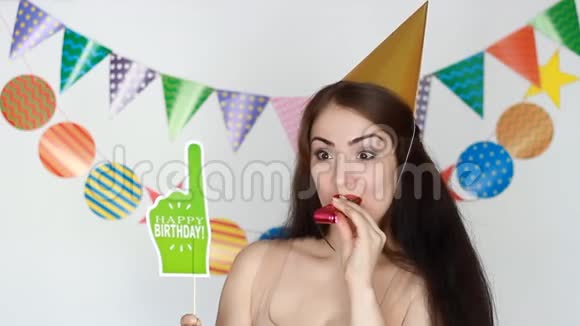 那个有趣的女孩微笑着吹着派对的号角生日快乐为庆祝做装饰视频的预览图