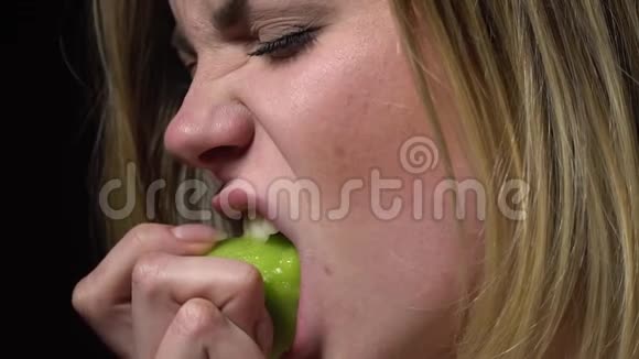 一个金发女人的脸咬掉了一个多汁的猕猴桃慢动作视频的预览图
