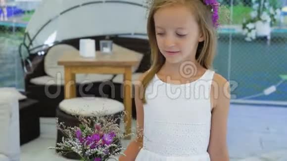 快乐的小女孩带着一束野花嗅着微笑着4K视频的预览图