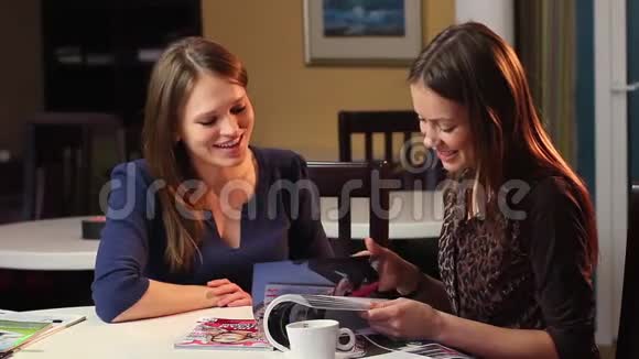 两个女朋友看杂志笑女伴笑视频的预览图