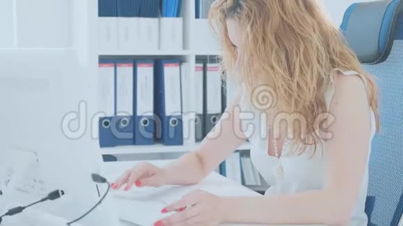 年轻女子在现代办公室的电脑键盘上打字视频的预览图