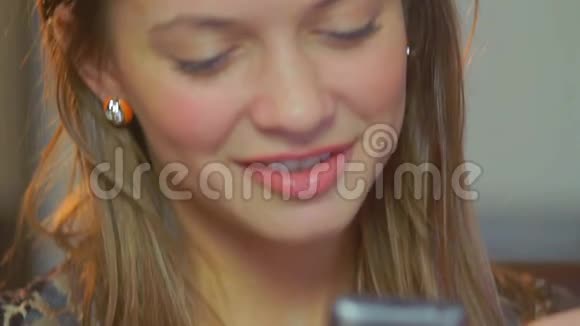 美丽的年轻女士调情手机微笑浪漫信息视频的预览图