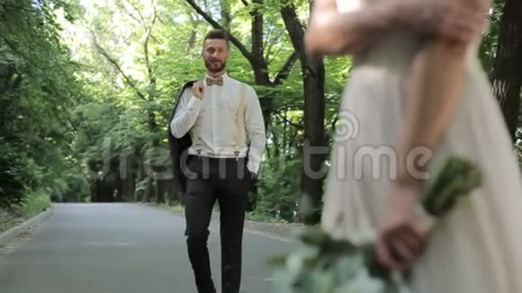 日落时分带着夹克的新郎来到公园里美丽的新娘视频的预览图