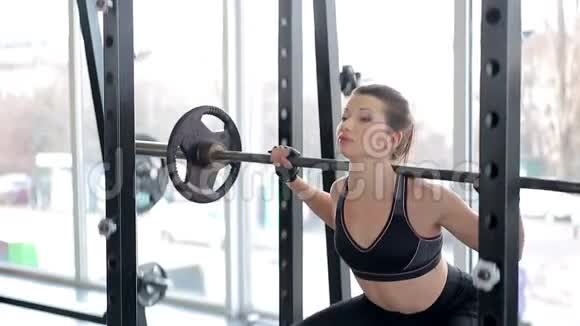健身女孩与身体做杠铃运动常规在健身房健康的生活方式视频的预览图