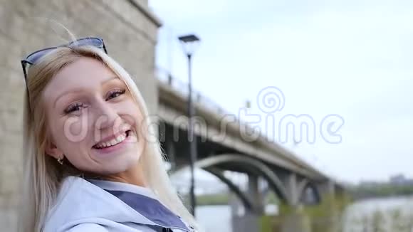 一个快乐兴奋的年轻女人正在她的智能手机上的网络摄像头上打动她的朋友一个女人谈论当地视频的预览图