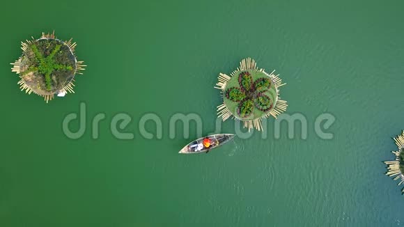 人们在湖边的小船上游泳绿水上漂浮的花坛在水上积极休息空中景观视频的预览图