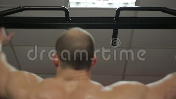 男性强壮的男性身体在酒吧做拉练积极锻炼视频的预览图