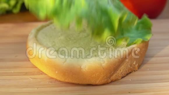 厨师把莴苣叶放在面包上视频的预览图