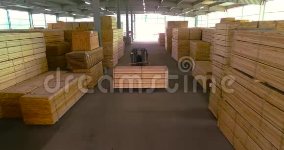 木材材料的大仓库叉车携带木梁穿过仓库整齐堆放的木条视频的预览图