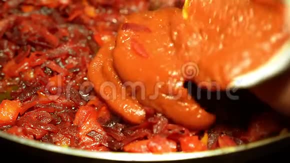 在蔬菜中加入番茄酱作为罗宋汤细碎的甜菜和胡萝卜用油煎锅煎视频的预览图
