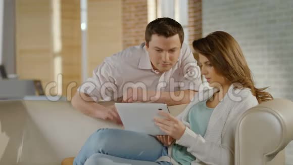 年轻人笑着在家玩平板电脑视频的预览图