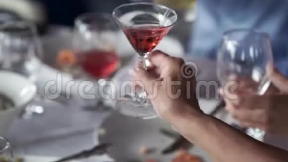 人们在桌旁聚会时碰杯视频的预览图
