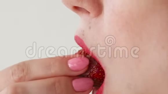 嘴唇红的女人吃草莓口特写侧视视频的预览图
