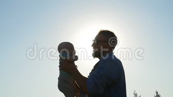 快乐的父亲在日落时分把孩子抛在空中家庭旅行度假父亲白天的概念视频的预览图