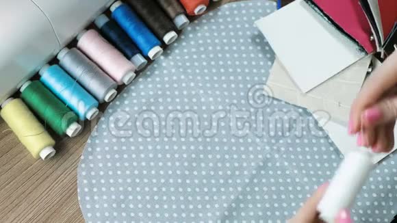 特写的女人她的手拿起线的颜色到灰色织物的圆点和皮革视频的预览图