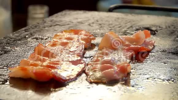 两条咸肉条在烤架上嘶嘶作响煎炸视频的预览图