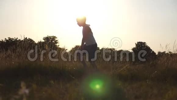在阳光明媚的日子里一个像飞机一样举起双手在草地上奔跑的小男孩小孩在草坪上慢跑视频的预览图