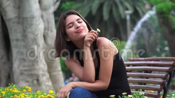 快乐的女孩子独自坐在公园里视频的预览图