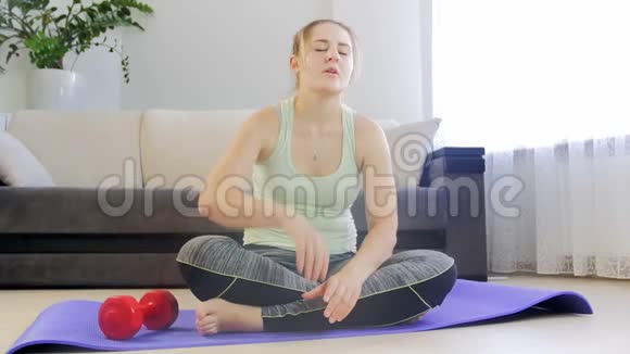 4k视频年轻出汗女子在家健身垫训练后呼吸困难视频的预览图