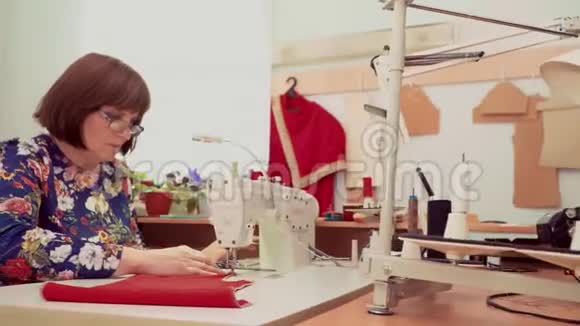 在工作室缝纫机工作的女人视频的预览图
