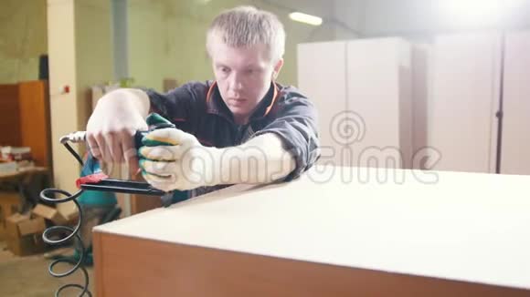 木匠在工厂用电动工业订书机工作修理家具零件视频的预览图