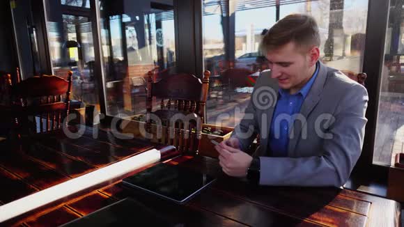 商人在平板电脑附近的智能手机咖啡馆聊天视频的预览图
