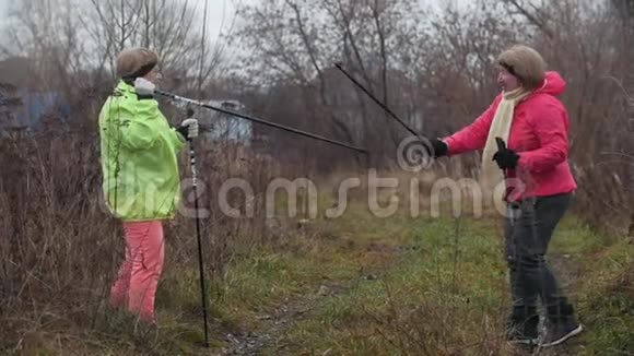 两个快乐的老年妇女玩得很开心用北欧的拐杖打架视频的预览图