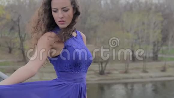 孤独的女孩站在桥上美丽的裙子秋风视频的预览图