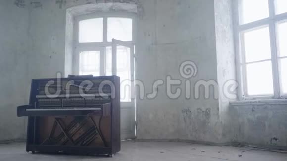 旧的空厅有白墙大窗户和废弃的木制钢琴视频的预览图