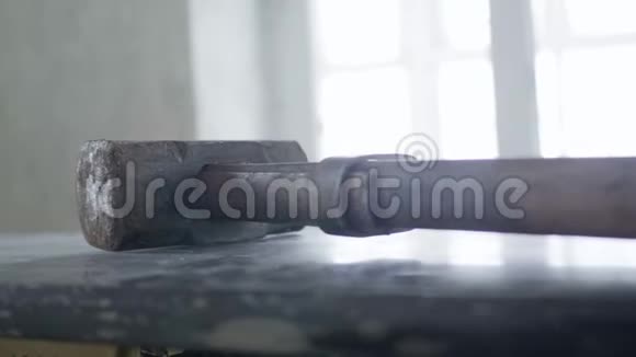 大金属锤躺在日光室的深色水平表面上视频的预览图