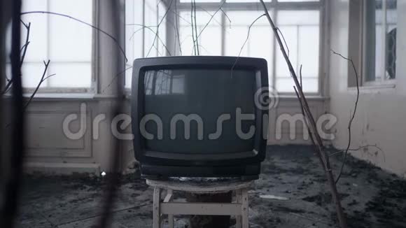 陈旧的黑色电视盒放在一楼空房间的旧木凳上视频的预览图