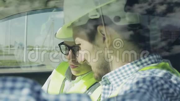 两个年轻的工程师一个男人和一个女人在绿色的背心和头盔视频的预览图