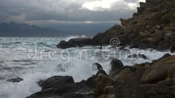 从撞击石岸的海浪中缓慢移动破碎的水滴Cerulean水丘向海岸倾斜视频的预览图