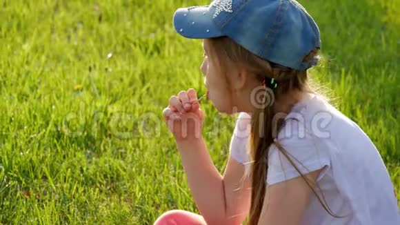 小女孩坐在草地上吃冰淇淋视频的预览图