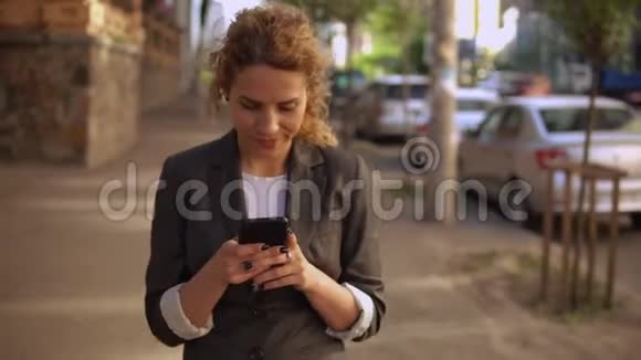 年轻的白种人女孩在户外使用手机视频的预览图