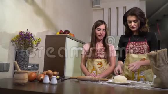 一个女人给朋友一块面团用擀面杖食物成分慢动作把面团卷出来视频的预览图