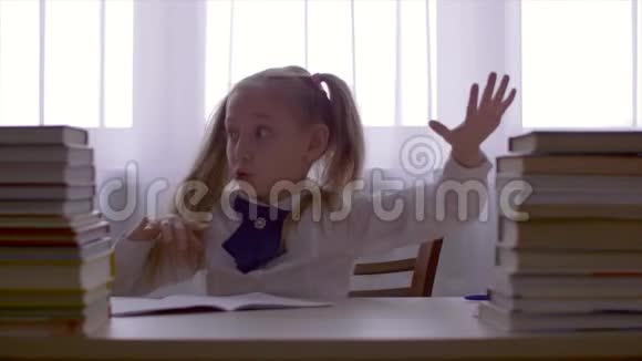 肖像学校女孩玩得很开心在桌上和课本堆跳舞视频的预览图