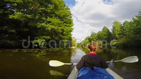女孩旅行者坐在皮艇里休息宽阔的河流缓慢的运动视频的预览图
