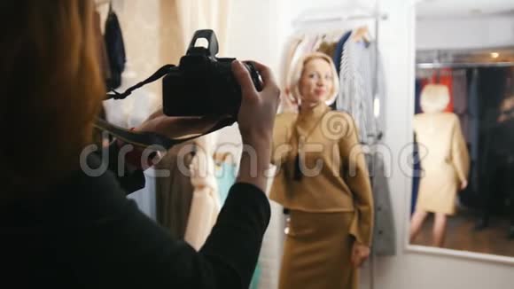 在服装精品陈列室为摄影师摆姿势的漂亮金发女郎视频的预览图
