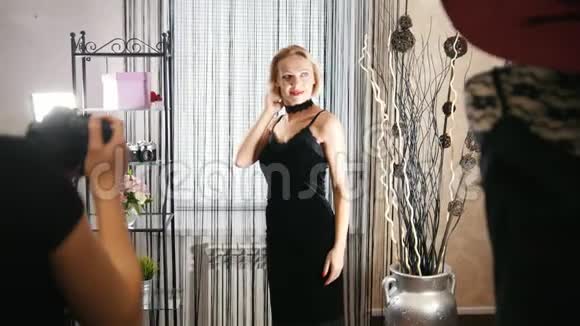 一位穿着鸡尾酒礼服的金发美女为服装精品店的摄影师摆姿势视频的预览图