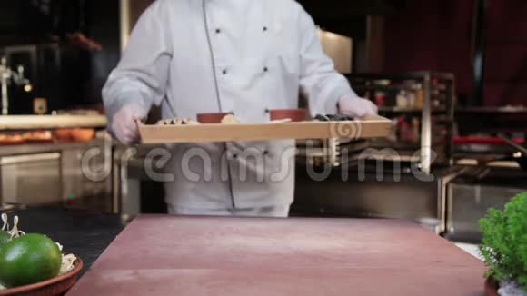 厨师端上现成的菜木盘寿司卷视频的预览图