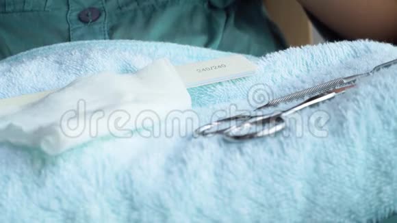 专业或家庭指甲躺在毛巾上的修指甲工具快关门使用美甲装置的女性家庭美甲视频的预览图