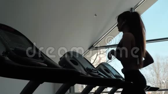 一个女人的后腰正准备在跑步机上跑步早上训练健康的瘦女孩视频的预览图