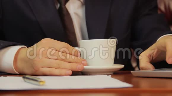 办公室工作人员喝咖啡检查笔记本电脑的信息视频的预览图
