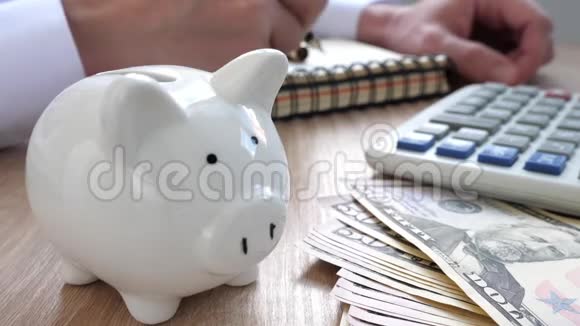 储蓄概念猪银行计算器和人写预算计划在一张纸条视频的预览图