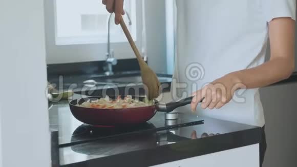 女人在煎锅上混合配料蔬菜视频的预览图