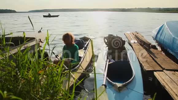 日落时的独木舟码头在船上等待的女孩美丽的自然视频的预览图