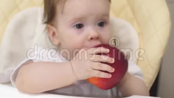 孩子坐在椅子上玩红苹果视频的预览图