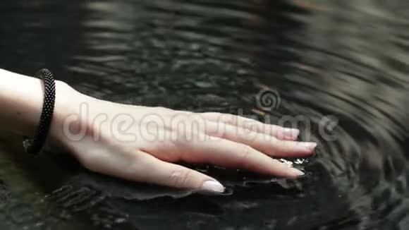 女人的手带着水花被傍晚的阳光背光一位年轻女子美丽的黝黑的手视频的预览图
